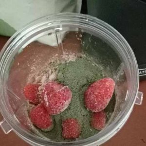 chocolate protein shake with greens balance and frozen strawberries